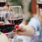 Wine tasting setup with glasses of Sonoma County wine in front of a vineyard